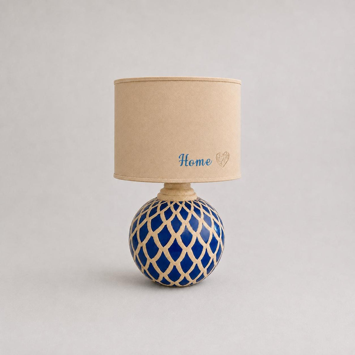 Vintage blue ceramic lamp base photographed with a lampshade for display; lampshade not included.