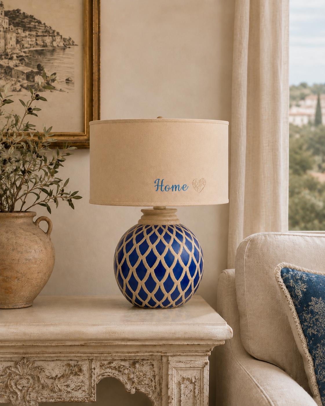 Vintage blue ceramic lamp base photographed with a lampshade for display; lampshade not included.