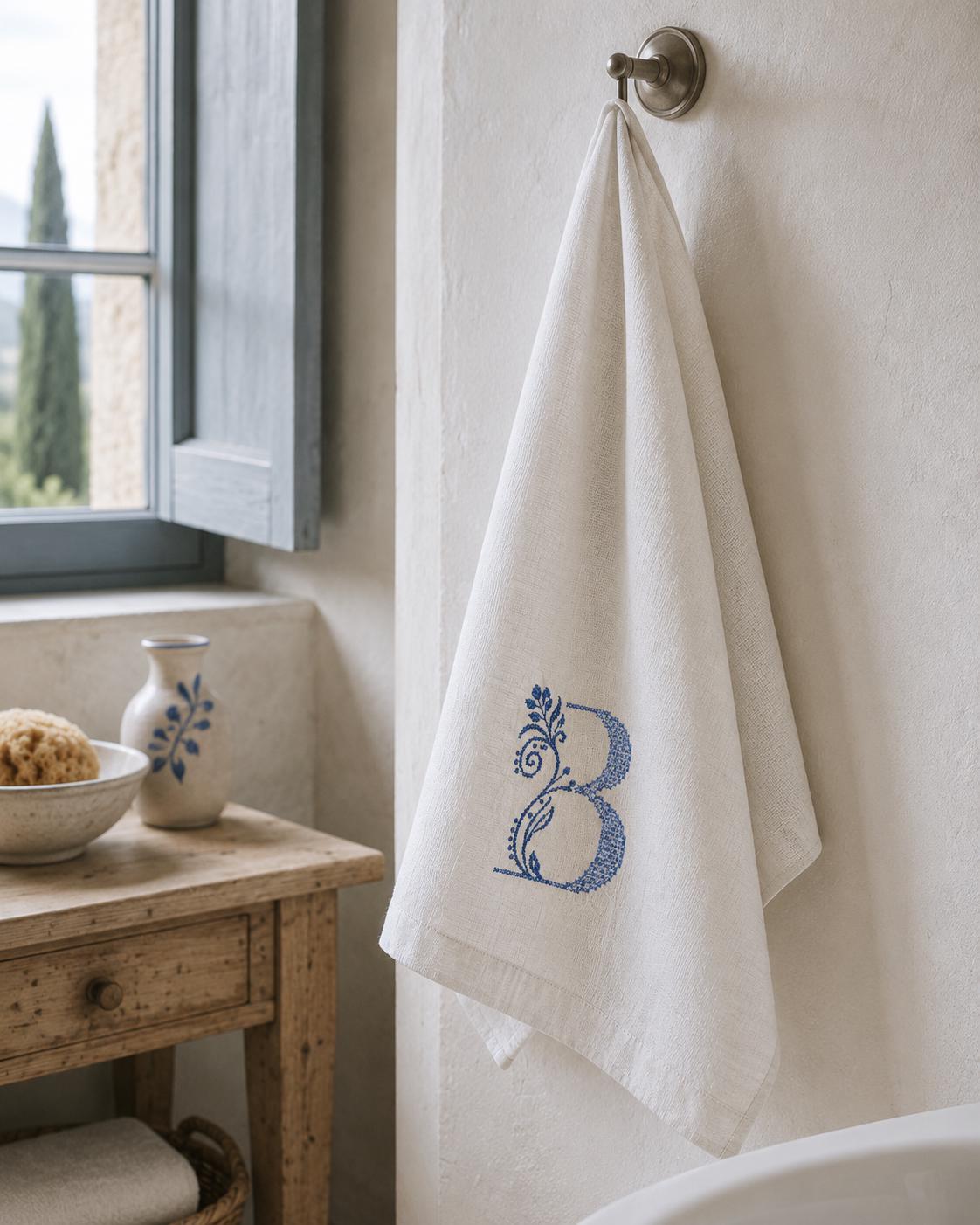 White Italian linen hand towel with blue embroidered botanical B monogram, 60 × 110 cm